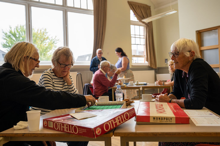 Members of Over 60's Social Club playing board game.